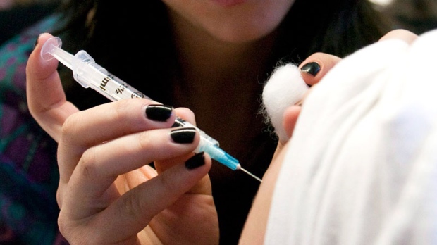 Nurse Laura Gill injects a vaccine into a young male at a vaccination clinic in Ottawa on Monday, Nov. 2, 2009. (Pawel Dwulit / THE CANADIAN PRESS)