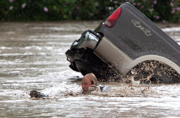 Kevan Yaets swims after his cat Momo as the floodwaters sweep him downstream and submerge the cab of his truck in High River, Alta. on June 20, 2013. (Jordan Verlage / THE CANADIAN PRESS)