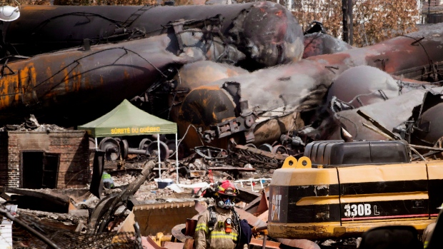 A fireman walks through the debris as work continues at the crash site of the train derailment and fire Tuesday, July 16, 2013 in Lac-Megantic, Que. that left 37 people confirmed dead and another 13 missing and presumed dead. (Ryan Remiorz / THE CANADIAN PRESS)