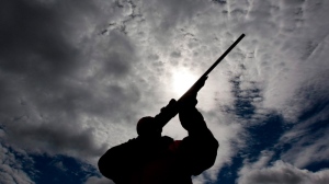 A rifle owner checks the sight of his rifle at a hunting camp property in rural Ontario west of Ottawa on Wednesday, Sept. 15, 2010. (Sean Kilpatrick / THE CANADIAN PRESS)