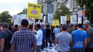 Several hundred workers demonstrate outside Montreal's City Hall Monday, Aug. 18, 2014. 