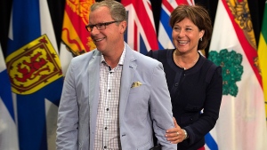 Saskatchewan Premier Brad Wall, left and British Columbia Premier Christy Clark share a light moment after announcing the lowering of trade barriers involving wine and some spirits between the two provinces at the annual Council of the Federation meeting in Charlottetown on Friday, Aug. 29, 2014. (Andrew Vaughan / THE CANADIAN PRESS)