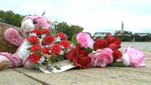 A vigil sits on the boardwalk near the Red River in Winnipeg 