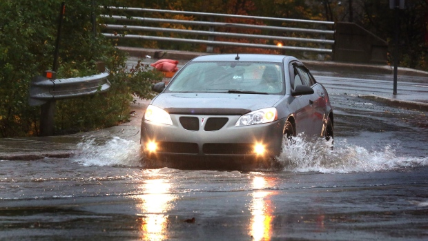 A car moves through a puddle in St.John's, N.L., Sunday, Oct.19, 2014. It was wet and windy, but southeastern Newfoundland received only a glancing blow from hurricane Gonzalo as the storm tracked offshore of the island overnight Sunday. (Paul Daly  / THE CANADIAN PRESS)