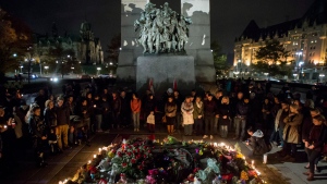 The Tomb of the Unknown Soldier at the National War Memorial is surrounded by people during a candlelight vigil in Ottawa on Saturday, Oct. 25, 2014. People gathered in tribute of Cpl. Nathan Cirillo, 24, a reservist from Hamilton, Ontario, who was killed on Wednesday. (Justin Tang / THE CANADIAN PRESS)