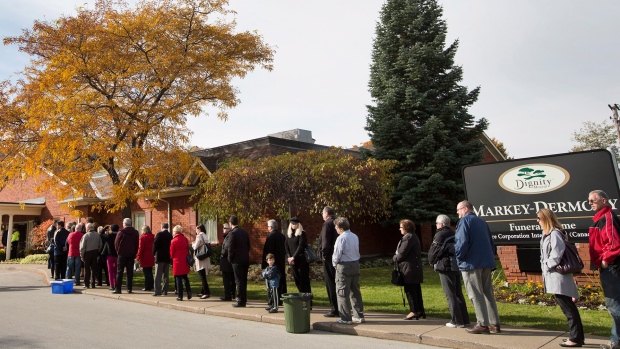 People wait in line to sign the book of condolences and attending the public visitation for Cpl. Nathan Cirillo at the Markey-Dermody Funeral Home in Hamilton, Ontario on Monday, Oct. 27, 2014. (Peter Power / THE CANADIAN PRESS)