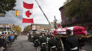 The body of Cpl. Nathan Cirillo is escorted through the streets toward his funeral service in Hamilton, Ont., on Tuesday, Oct. 28, 2014. (Peter Power / THE CANADIAN PRESS)