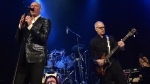 Glenn Gregory, centre, and Tony Visconti, right, former producer for rock legend David Bowie, perform as part of the group Holy Holy, during a tribute concert playing covers from Bowie's 1970 album 'The Man Who Sold The World' in its entirety, at Toronto's Opera House concert venue, on Tuesday, Jan. 12, 2016. (Nathan Denette / THE CANADIAN PRESS)