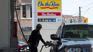 A woman pumps gas in Toronto in this file photo. (Nathan Denette / THE CANADIAN PRESS)