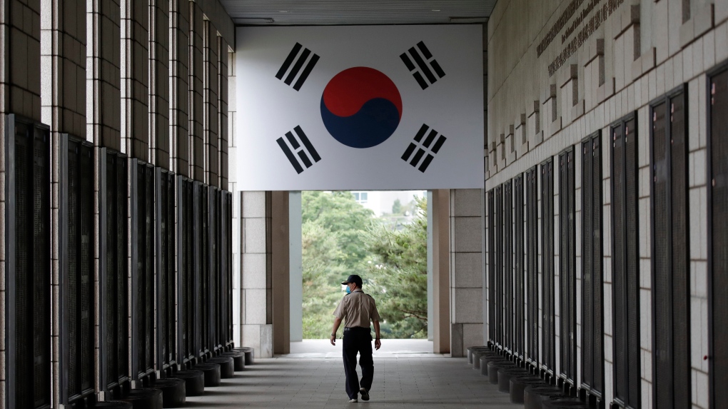 A man wearing a face mask as a precaution against the new coronavirus, walks near the names of U.S. and U.N. soldiers who were killed in the Korean War, at the War Memorial of Korea in Seoul, South Korea, Thursday, June 25, 2020. (AP Photo/Lee Jin-man)