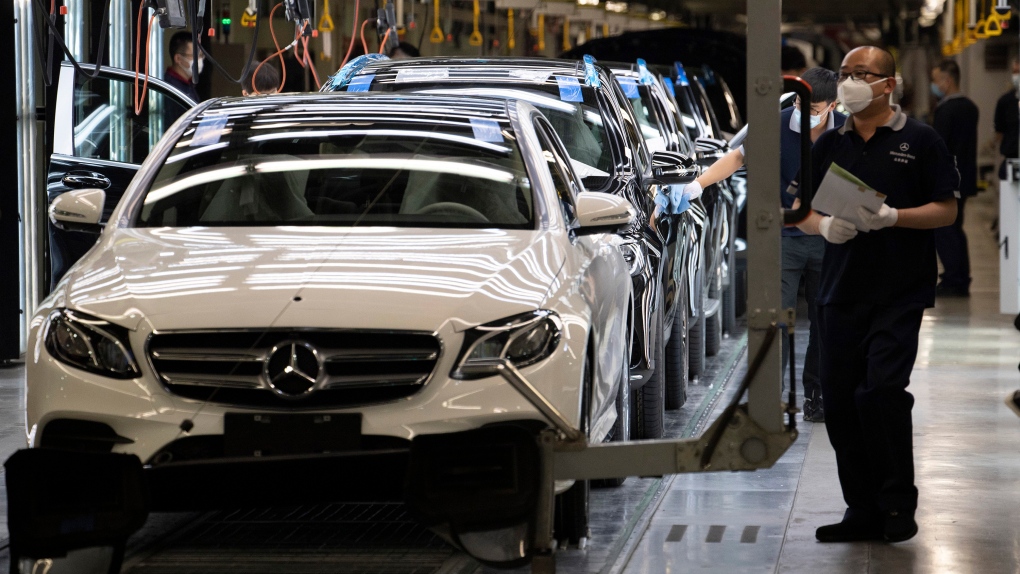 Workers inspect newly assembled cars at a Beijing Benz Automotive Co. Ltd factory, a German joint venture company for Mercedes-Benz, in Beijing on Wednesday, May 13, 2020. (AP Photo/Ng Han Guan)
