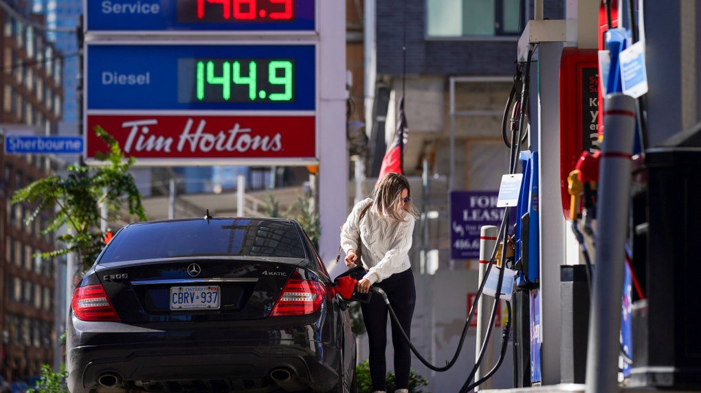 A woman fills her vehicle with fuel during the COVID-19 pandemic in Toronto on Tuesday, October 19, 2021. Gas prices across Canada and the world are hitting record highs. THE CANADIAN PRESS/Evan Buhler 