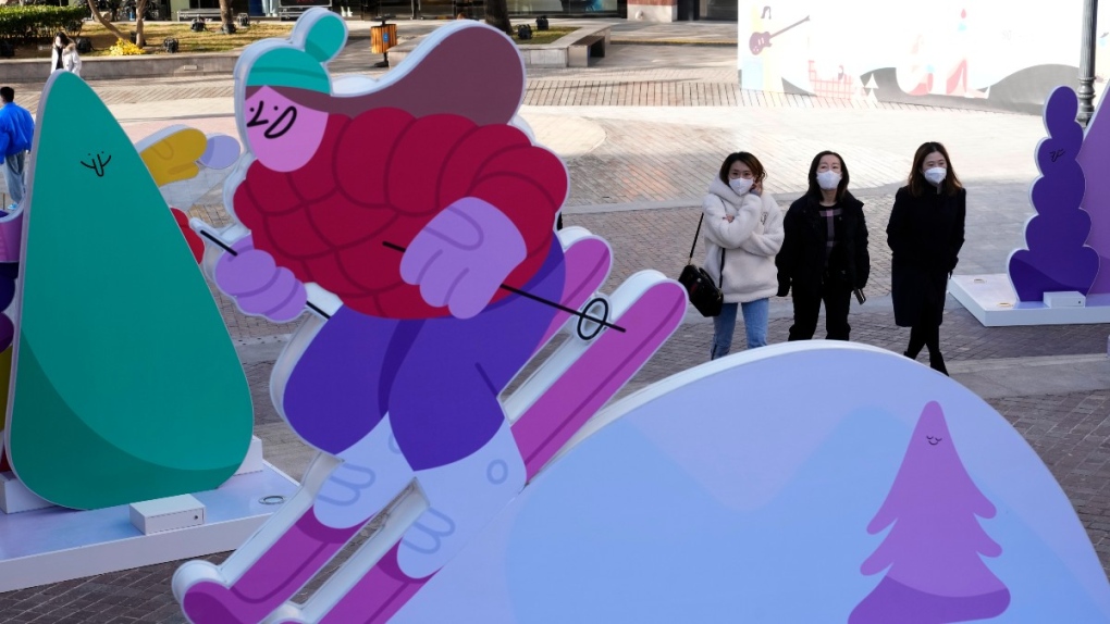 Visitors to a mall walk past winter sports themed cartoon sculpture in Beijing, China, on Nov. 24, 2021. (Ng Han Guan / AP) 