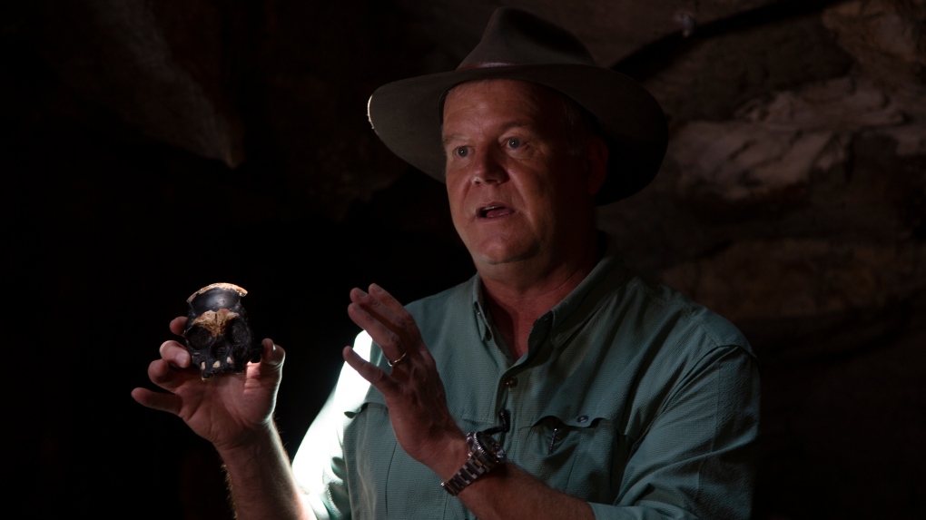 Professor Lee Berger, from the University of the Witwatersrand, holds a replica of the discovered Homo Naledi fossil inside the Rising Star Cave in the Cradle of Humankind World Heritage Site near Johannesburg, Thursday, Nov. 4, 2021. (AP Photo/Denis Farrell) 