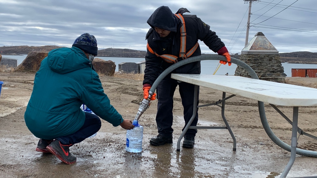 Residents line up to fill containers with potable water in Iqaluit, Nunavut on Thursday, Oct. 14, 2021. (THE CANADIAN PRESS / Emma Tranter)