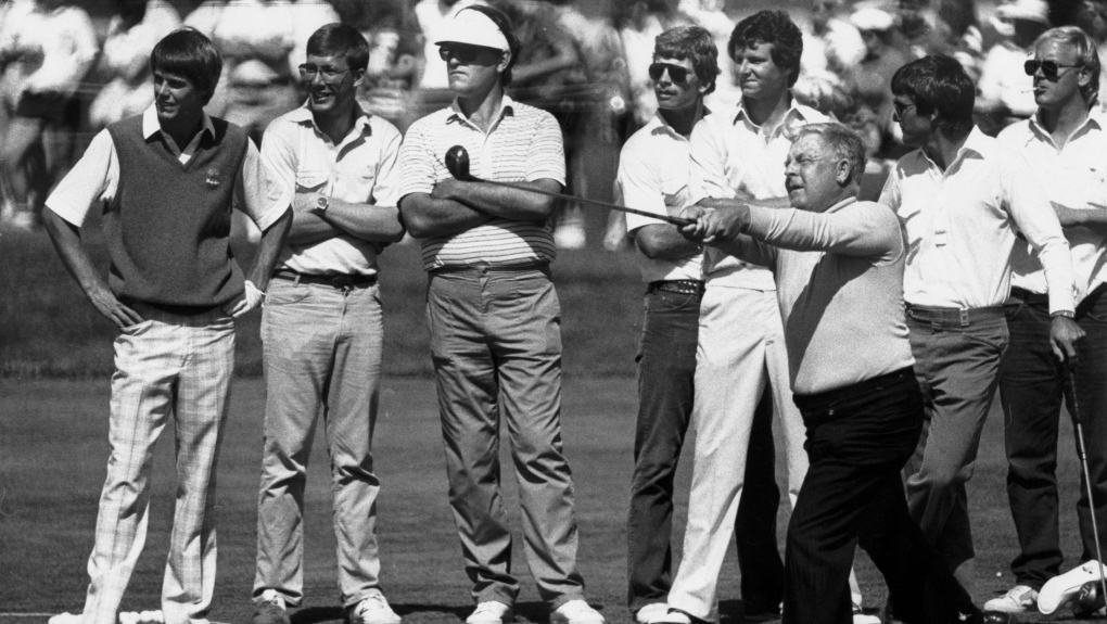 Canadian amateur golfer Moe Norman demonstrates his unorthodox style to a group of young tour golfers at Glen Abbey in Oakville, Ont. on June 26, 1984. The Canadian Press/Tim Clark 

