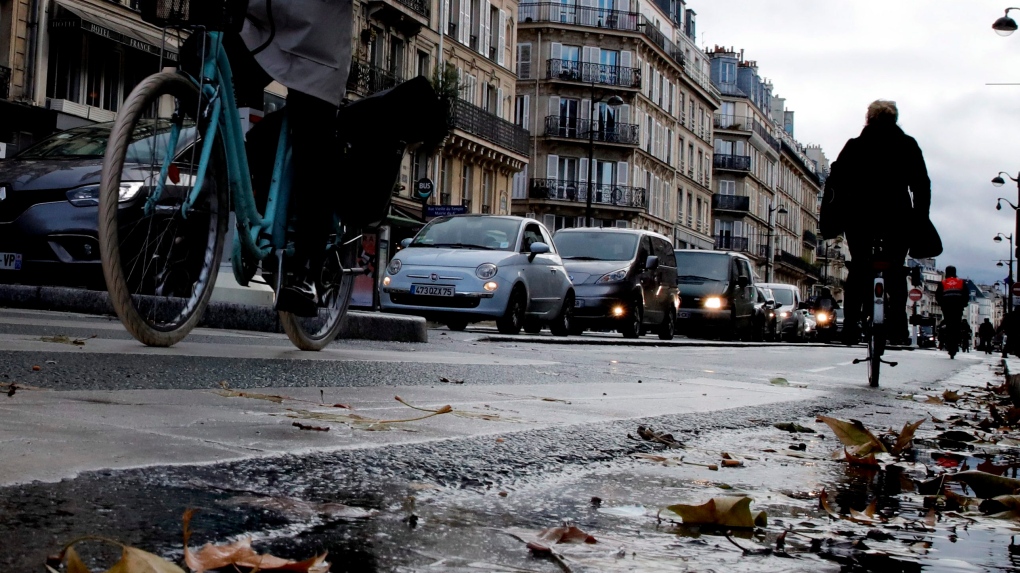 Parisians ride bicycles in the traffic jam, in Paris, Friday, Dec. 20, 2019. (AP Photo/Christophe Ena) 