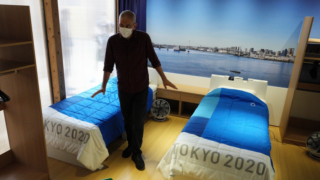 A journalist looks at cardboard beds for the Tokyo 2020 Olympic and Paralympic Villages, which are shown in a display room the Village Plaza on June 20, 2021, in Tokyo. (AP Photo/Eugene Hoshiko) 