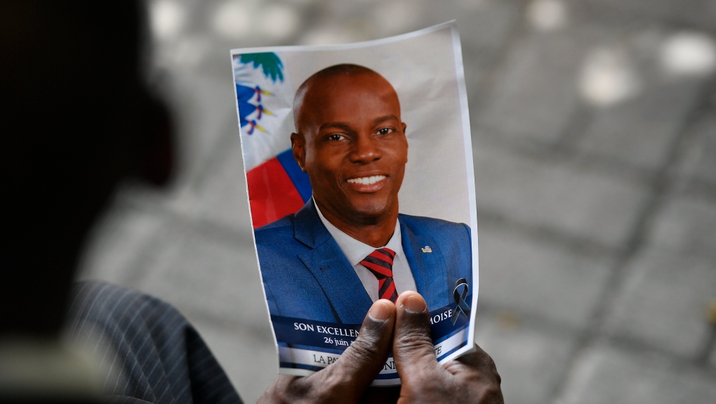 A person holds a photo of late Haitian President Jovenel Moise during his memorial ceremony at the National Pantheon Museum in Port-au-Prince, Haiti, Tuesday, July 20, 2021. Moise was assassinated at home on July 7. (AP Photo/Matias Delacroix) 