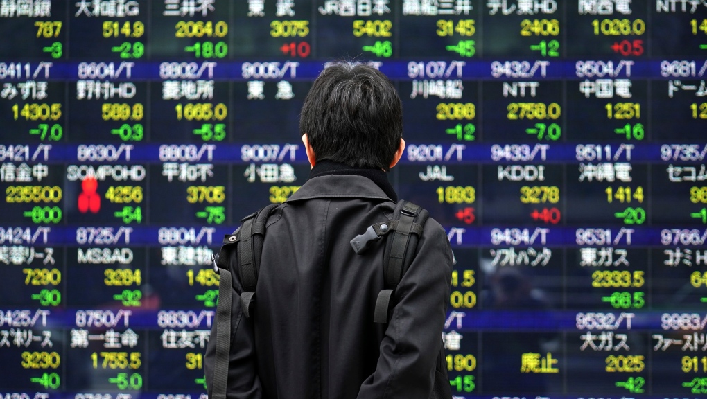 A man looks at an electronic stock board at a securities firm in Tokyo Friday, Jan. 15, 2021. (AP Photo/Eugene Hoshiko)
