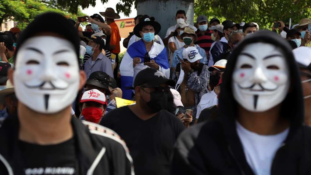 Men wear Guy Fawkes masks during an anti-government match to protest the policies of President Nayib Bukele, in San Salvador, El Salvador, Sunday, Oct. 17, 2021. (AP Photo/Salvador Melendez) 