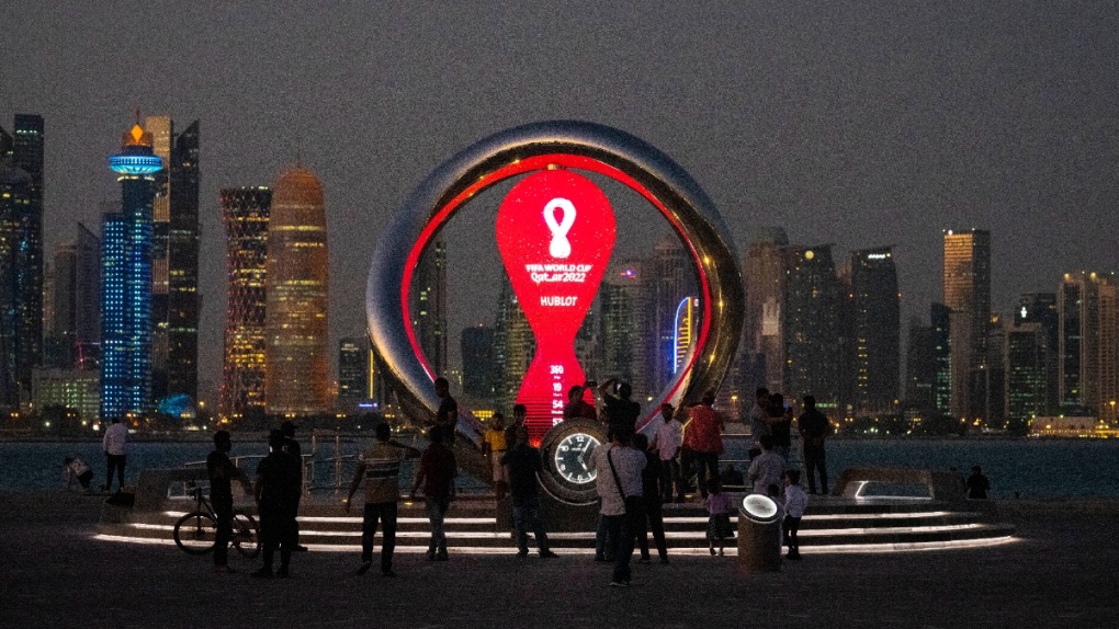 People gather around the official countdown clock showing remaining time until the kick-off of the World Cup 2022, in Doha, Qatar, on Nov. 25, 2021. (Darko Bandic / AP) 