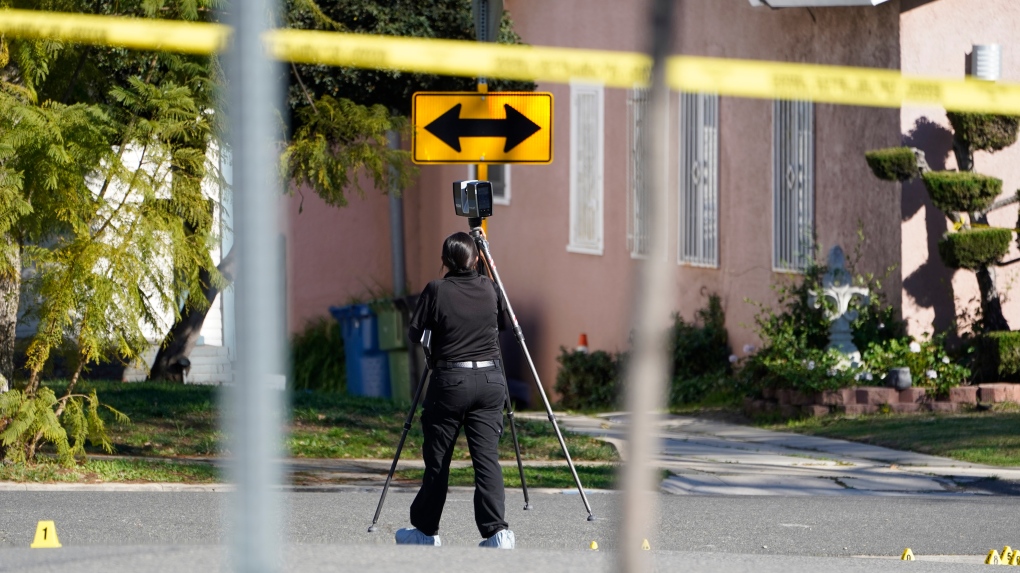 An Inglewood Police forensic investigator scans the street area near the scene of shooting in Inglewood, Calif., Sunday, Jan. 23, 2022. Authorities said several were killed when multiple shooters opened fire at a house party near Los Angeles early Sunday. (AP Photo/Damian Dovarganes) 