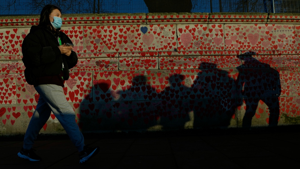 A pedestrian passes the COVID Memorial Wall in London, Friday, Jan. 14, 2022. (AP Photo/Kirsty Wigglesworth) 
