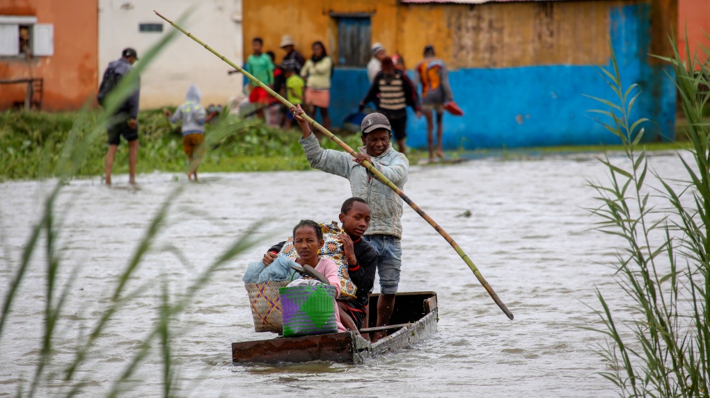 A family take their belongings after their home was flooded after a week long of heavy rain, in Antananarivo, Madagascar, Jan. 24, 2022.  (AP Photo/Alexander Joe)