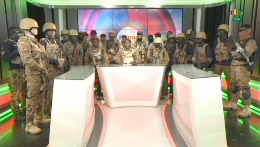 In this image from video broadcast by RTB state television, coup spokesman Capt. Kiswendsida Farouk Azaria Sorgho reads a statement in a studio in Ougadougou, Burkina Faso, on Friday evening, Sept. 30, 2022. (RTB via AP)