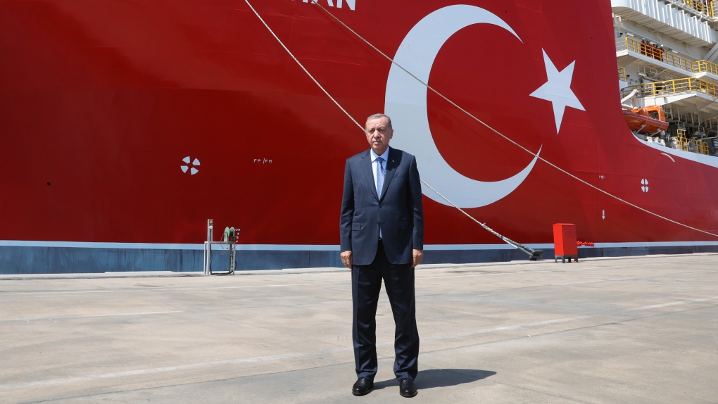 In this photo provided by the Turkish Presidency, Turkey's President Recep Tayyip Erdogan stands in front of Abdulhamid Han ship, in Mersin, Turkey, Tuesday, Aug. 9, 2022. (Turkish Presidency via AP)
