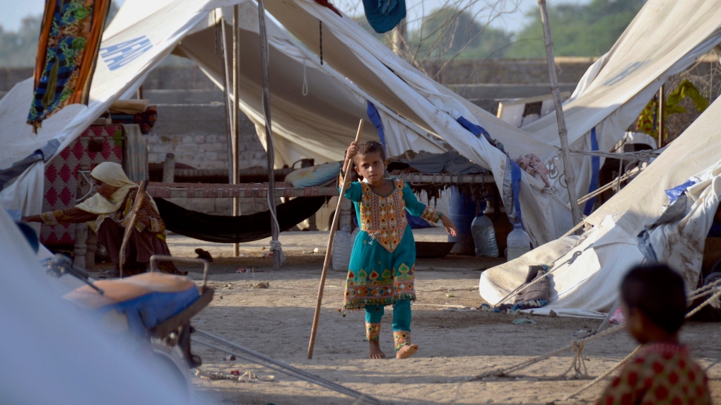 A young girl plays outside her tent at a relief camp, in Jaffarabad, a district in the southwestern Baluchistan province, Pakistan, Thursday, Sept. 29, 2022. (AP Photo/Zahid Hussain)