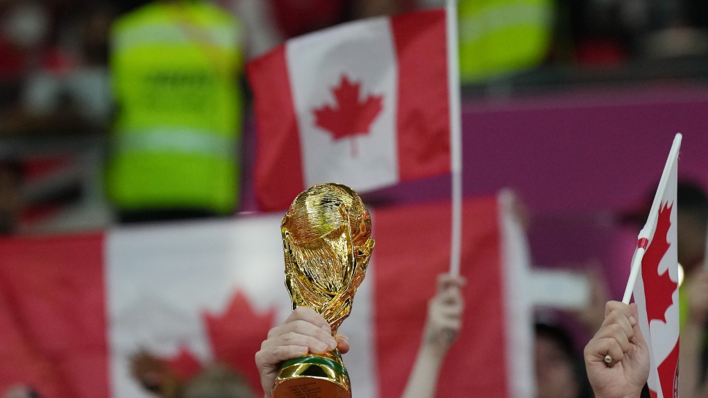 A Canada fan holds a replica World Cup trophy as they cheer ahead of Group F World Cup soccer action between Canada and Belgium at Ahmad bin Ali Stadium in Al Rayyan, Qatar, on Wednesday, Nov. 23, 2022. THE CANADIAN PRESS/Nathan Denette