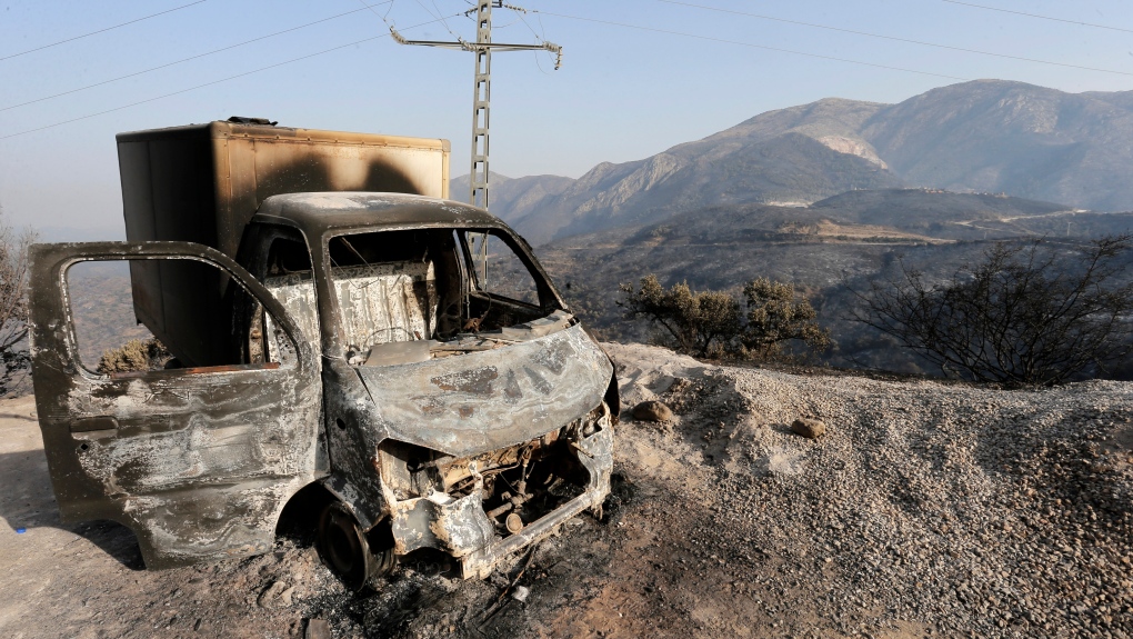 A charred truck is pictured after a fire near the village of Achlouf, in the Kabyle region, east of Algiers, Friday, Aug. 13, 2021. (AP Photo/Toufik Doudou, File)