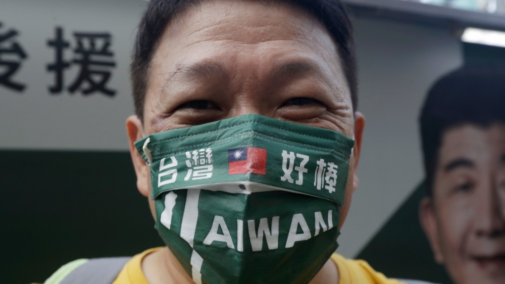 A supporter wears a mask patterned with the Taiwan national flag and slogan reading "Taiwan is awesome" during an election campaign in Taipei, Taiwan, Nov. 20, 2022. (AP Photo/Chiang Ying-ying)
