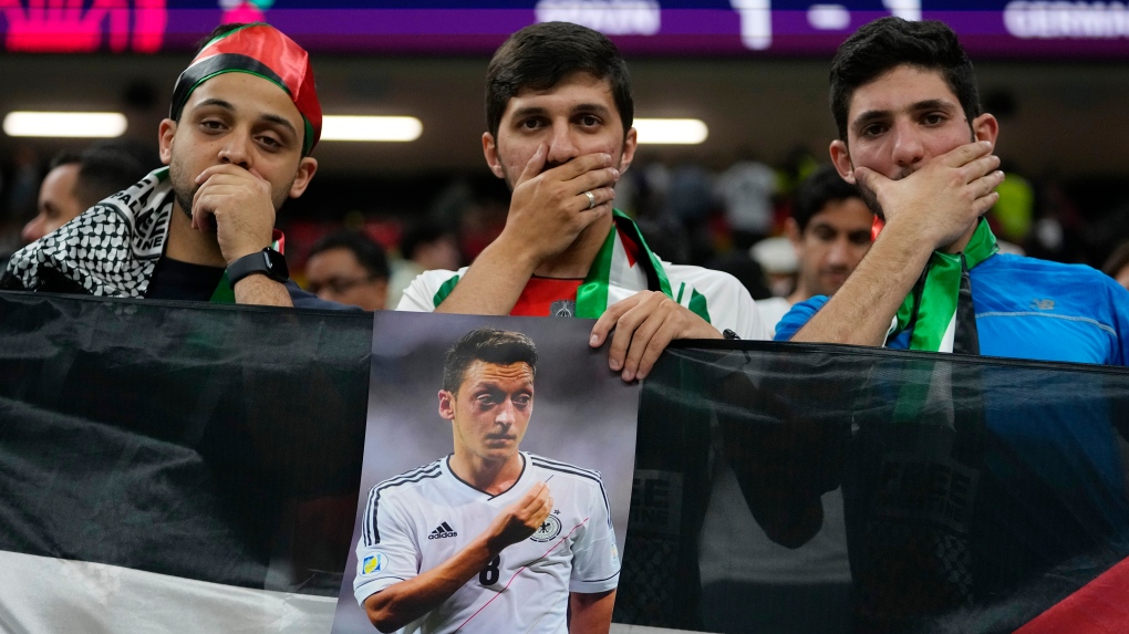 Spectators hold photo of Forman German international Mesut Ozil on the stands at the end of the World Cup group E soccer match between Spain and Germany, at the Al Bayt Stadium in Al Khor , Qatar, Monday, Nov. 28, 2022. (AP Photo/Julio Cortez)