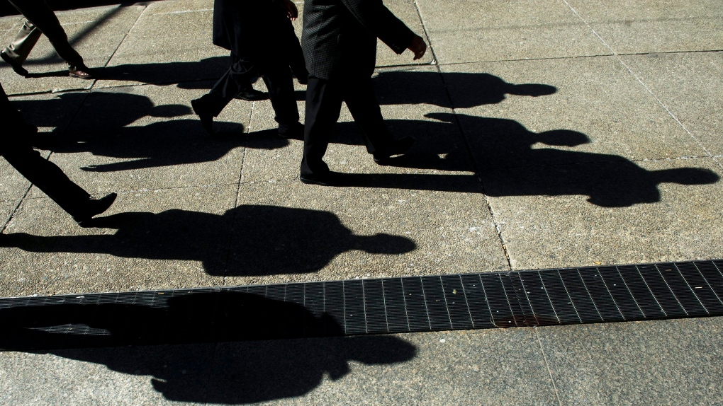 Workers cast shadows as they walk in Toronto's financial district on Monday, Feb. 27, 2012. A survey of Canadian employers by one of Ontario’s largest pension providers found that among their top concerns are employee burnout, high turnover, and the ongoing labour shortage.THE CANADIAN PRESS/Nathan Denette