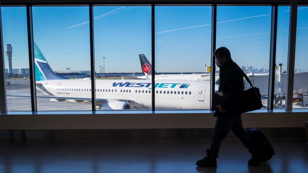 Passengers walk past Air Canada and WestJet planes at Calgary International Airport in Calgary, Alta., Wednesday, Aug. 31, 2022. THE CANADIAN PRESS/Jeff McIntosh