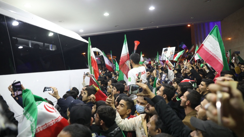 Iran fans wave flags as they gather at Imam Khomeini Airport in Tehran on Dec. 1, 2022 to greet the Iranian national team upon their return after competing in the Qatar 2022 World Cup. - The United States beat Iran 1-0 to reach the knockout phase of the World Cup on November 29. (Photo by Hadi Zand/ISNA/AFP via Getty Images)