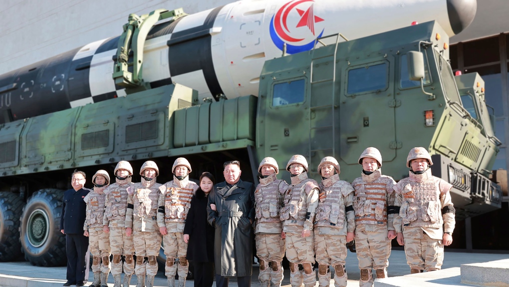 This undated photo provided on Nov. 27, 2022, by the North Korean government shows North Korean leader Kim Jong Un, centre, and his daughter, center left, pose with soldiers for a photo, in front of what it says a Hwasong-17 intercontinental ballistic missile, at unidentified location in North Korea. (Korean Central News Agency/Korea News Service via AP)
