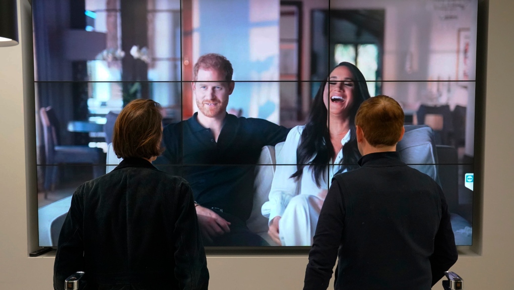 Office workers watch the Duke and Duchess of Sussex's controversial documentary being aired on Netflix, in London, Dec. 8, 2022. THE CANADIAN PRESS/AP-PA, Jonathan Brady