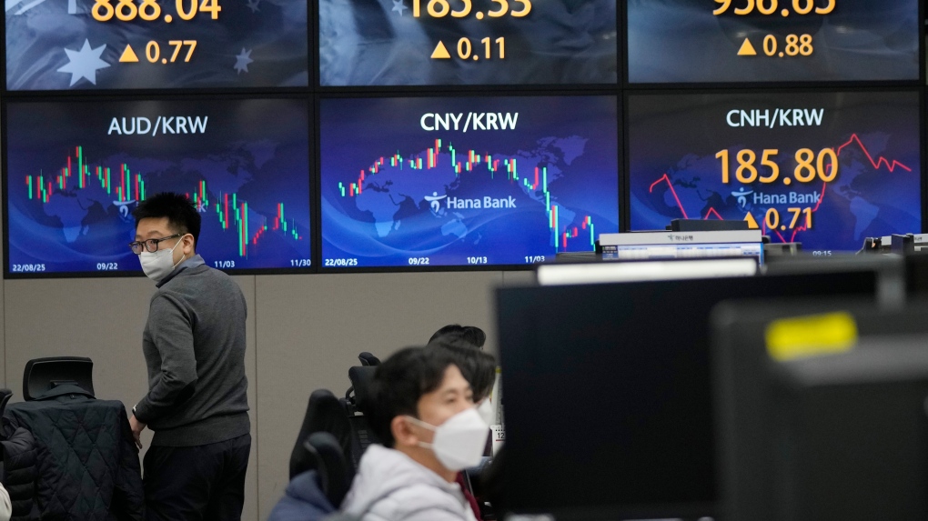 A currency trader passes by the screens showing the foreign exchange rates at the foreign exchange dealing room of the KEB Hana Bank headquarters in Seoul, South Korea, Wednesday, Nov. 30, 2022. (AP Photo/Ahn Young-joon)
