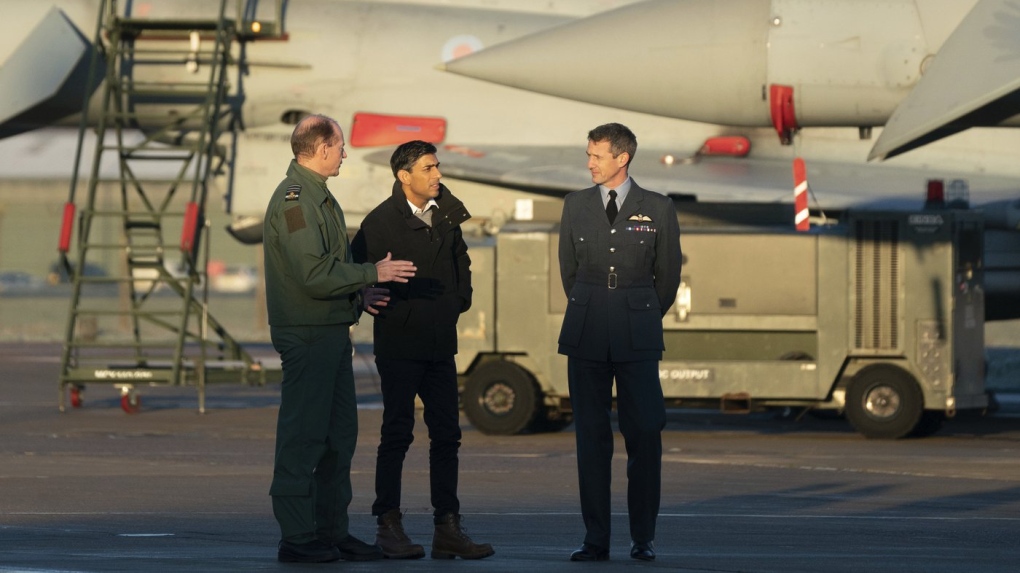 Air Chief Marshal Mike Wigston, left and Station Commander for RAF Coningsby Billy Cooper walk with Britain's Prime Minister Rishi Sunak during his visit to RAF Coningsby in Lincolnshire, England, Friday, Dec. 9, 2022, following the announcement that Britain will work to develop next-generation fighter jets with Italy and Japan. (Joe Giddens/Pool Photo via AP)