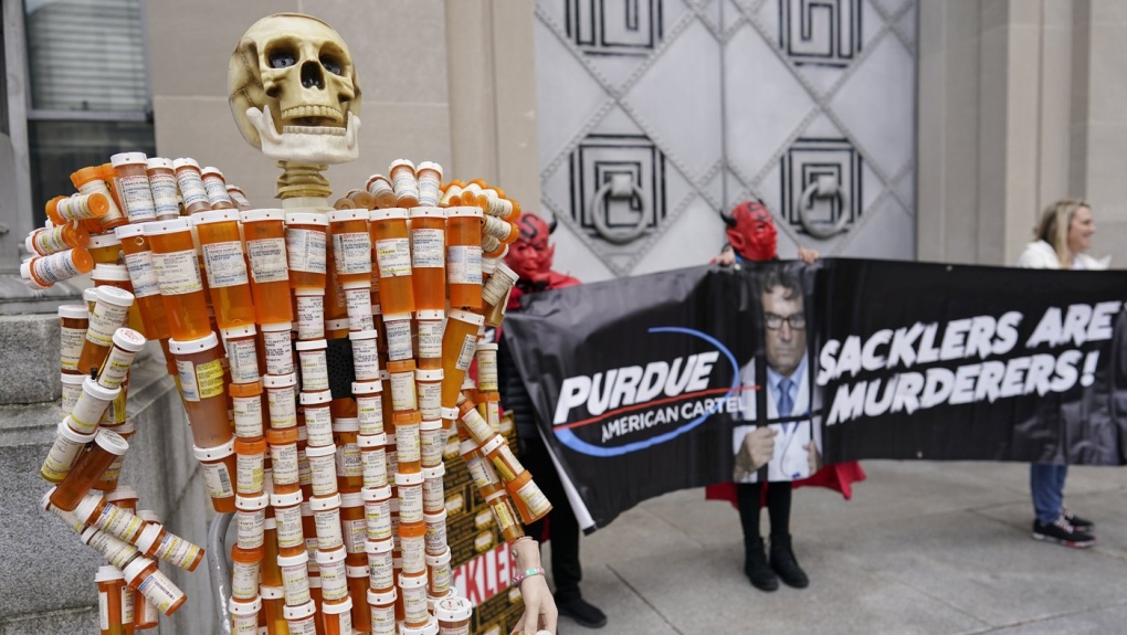 "Pill Man" made by Frank Huntley of Worcester, Mass., from his opioid prescription pill bottles, is displayed during a protest by advocates for opioid victims outside the Department of Justice on Dec. 3, 2021, in Washington. (AP Photo/Carolyn Kaster)