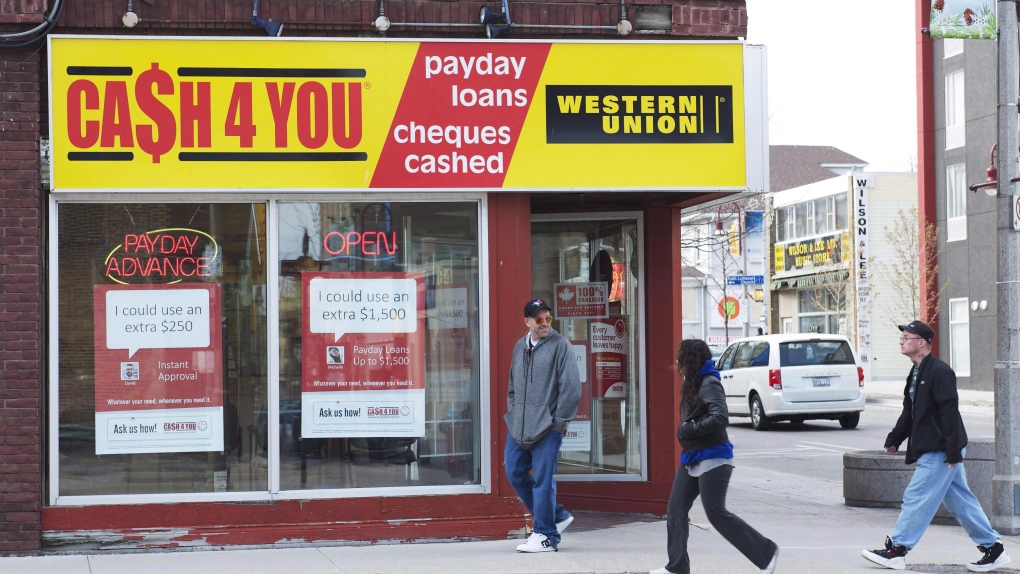 People walk pass a payday loan store in Oshawa, Ont., on May 13, 2017. THE CANADIAN PRESS/Doug Ives