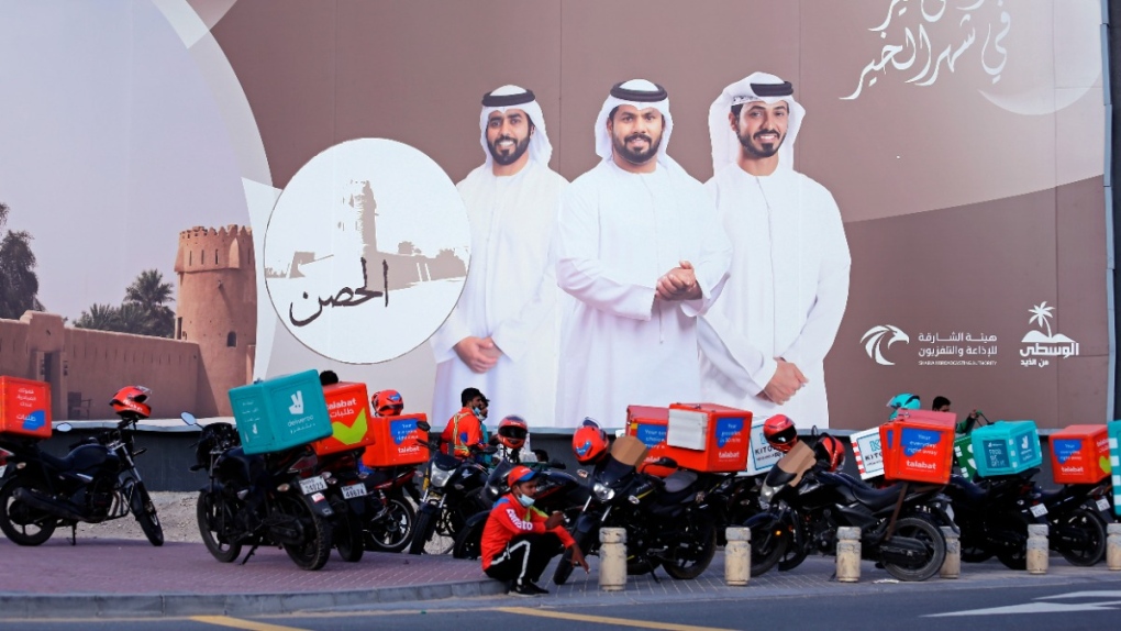 Food-delivery drivers take a break in Dubai, United Arab Emirates, on May 2, 2022. (Isabel Debre / AP) 