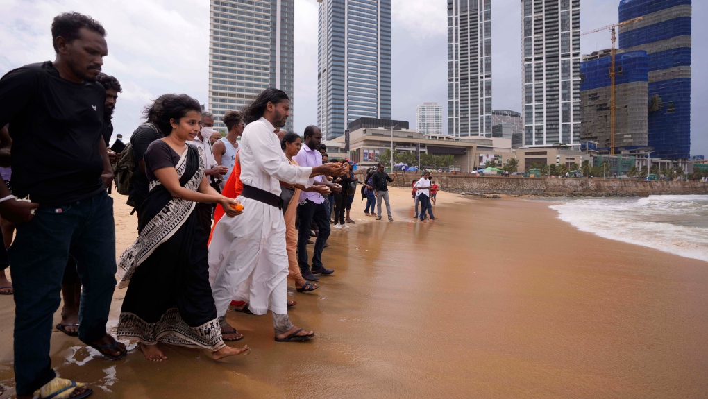 Human rights activists walk to offer flowers to the sea in remembrance of victims of Sri Lanka's civil war, at the ongoing anti government protest site in Colombo, Sri Lanka, Wednesday, May 18, 2022.  (AP Photo/Eranga Jayawardena)
