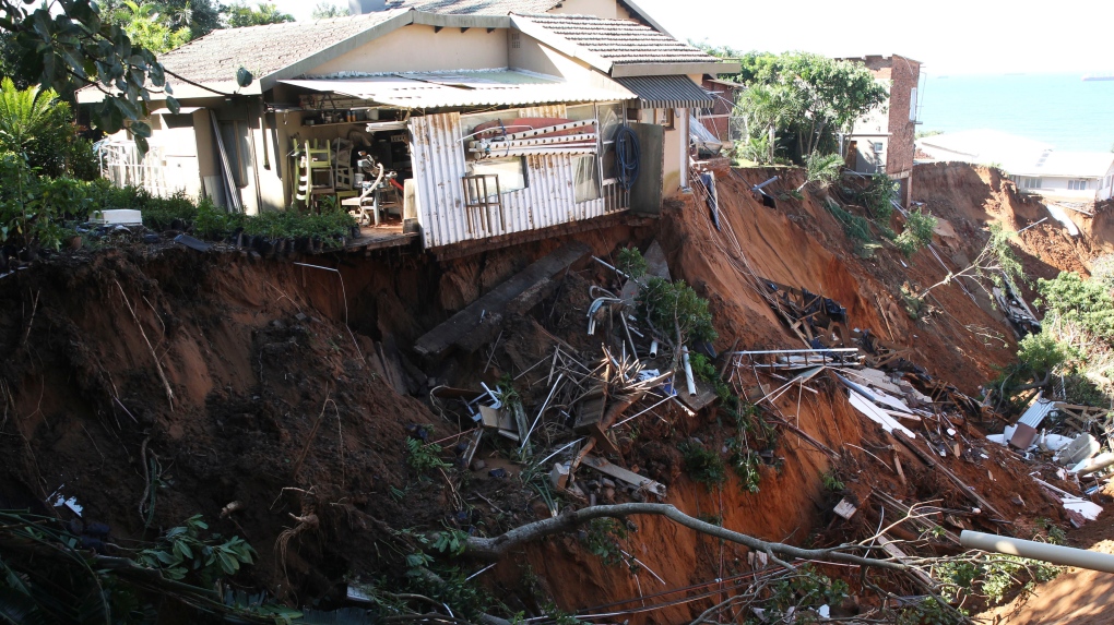Damaged homes on the edge of a precipice caused by flooding waters near Durban, South Africa, Monday, May 23, 2022. (AP Photo)