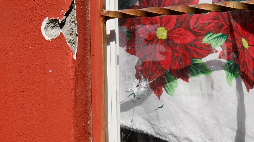 FILE - Bullet holes mark the wall and window of a home, after gunmen opened fire the previous night on mourners at a wake out front, on the outskirts of Celaya, Guanajuato State, Mexico, Friday, Jan. 8, 2021. (AP Photo/Mario Armas)