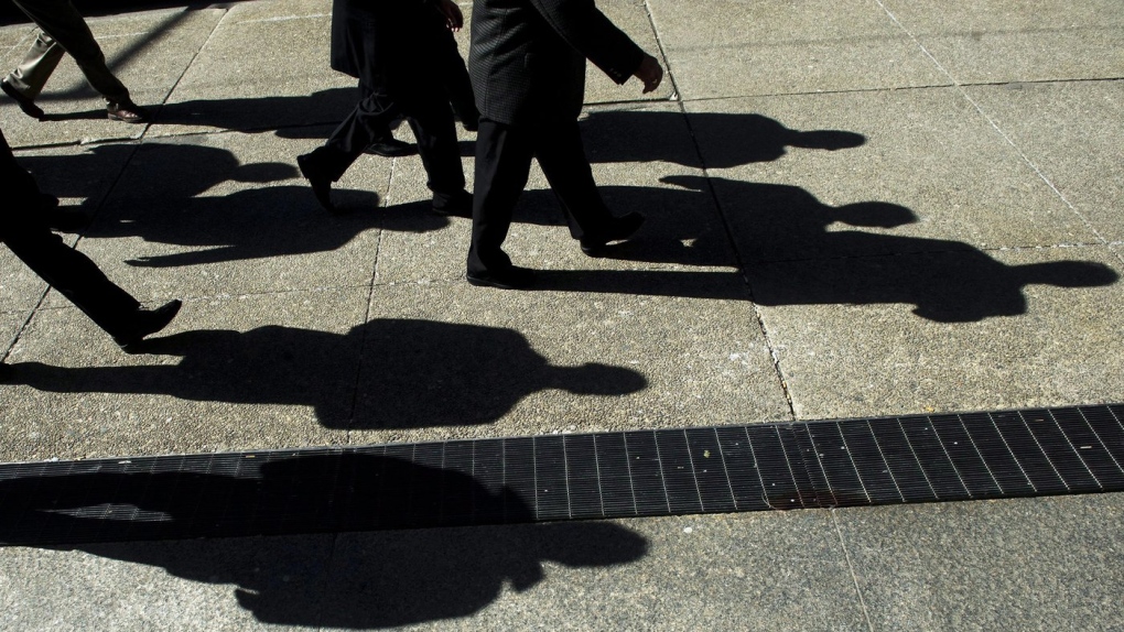 Businessmen cast their shadows as they walk in Toronto's financial district, Feb. 27, 2012. THE CANADIAN PRESS/Nathan Denette